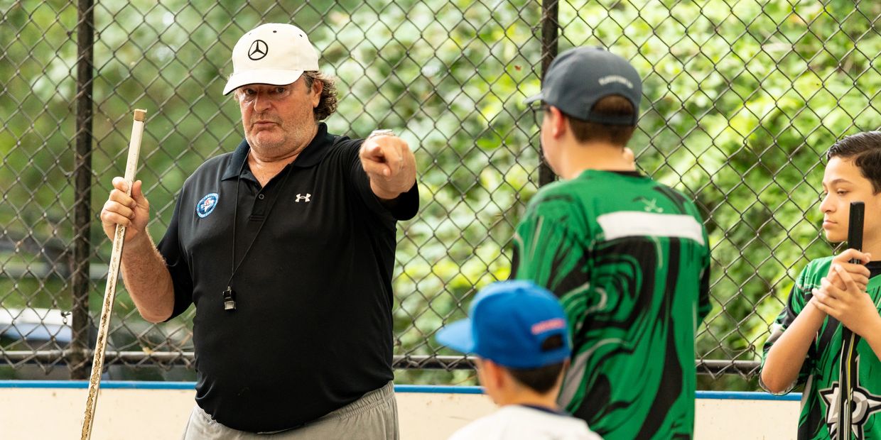 Coach instructing young hockey players during practice.