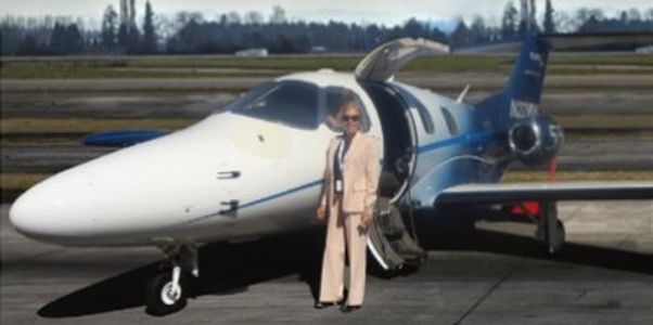 Woman standing in front of a private jet.