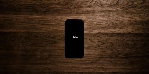 Smartphone on wooden desk with ‘Hello’ screen representing CRM adoption onboarding