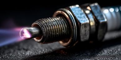 Close-up of a spark plug with a glowing tip.