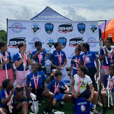 Youth football team celebrating with medals on field.