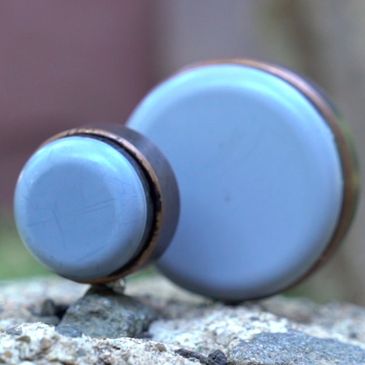 Two blue cylindrical objects on a rocky surface.