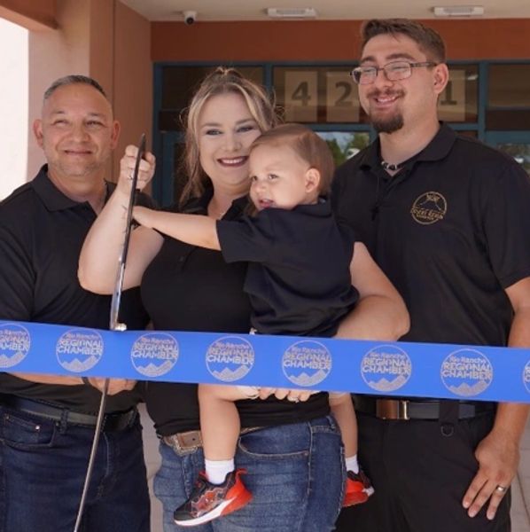 Family celebrates ribbon-cutting event with toddler.
