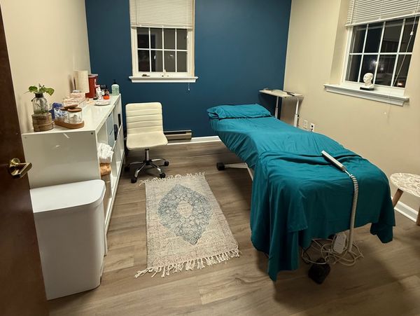 Calm treatment room with teal therapy bed.