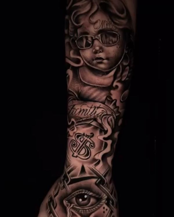 Black and grey tattoo sleeve with a baby, lettering, dollar sign, and eye design.