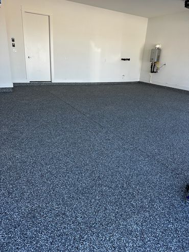Garage concrete floor resurfaced with PolyChip flake system for garage floors.