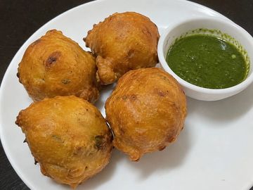 Plate of Indian pakoras with green chutney.
