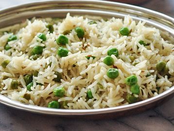 Plate of rice dish with green peas.