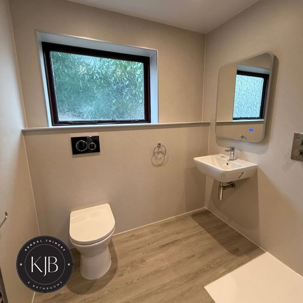 Minimalist bathroom with toilet, sink, and frosted window.