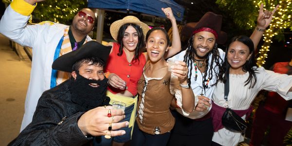 Group of friends in costumes enjoying a lively night celebration outdoors.
