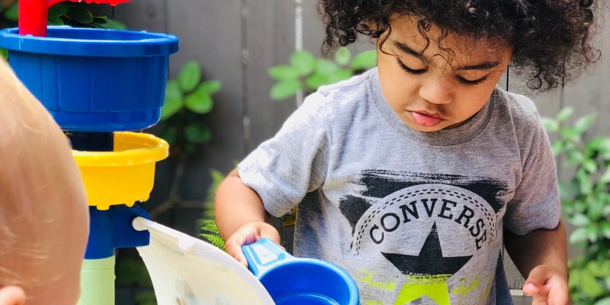 Toddlers engaged in sensory water table play at Adventure House childcare in Burnaby