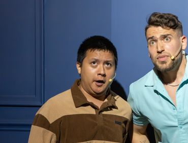 Two men on stage, appearing surprised or shocked during a performance.