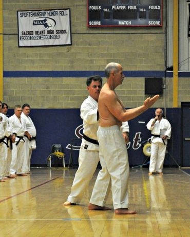 Karate instructors practicing a self-defense drill with a block.