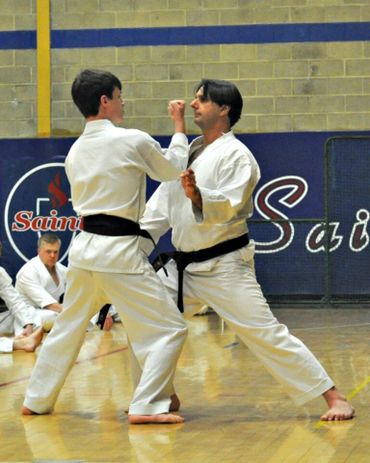 Two karate students engaged in a close-quarters partner training drill.