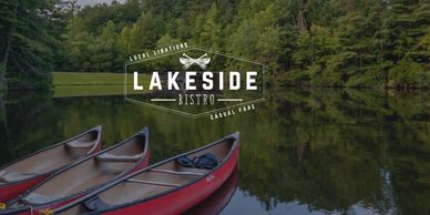 Three red canoes on a calm lake with dense green forest reflection.