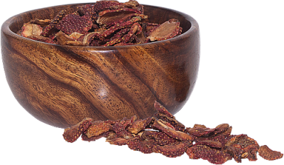 Wooden bowl filled with dried strawberry slices, some spilled outside.