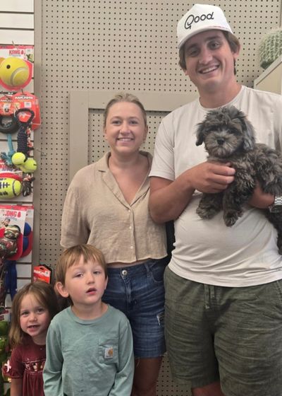 Family posing with their dog in a pet store.