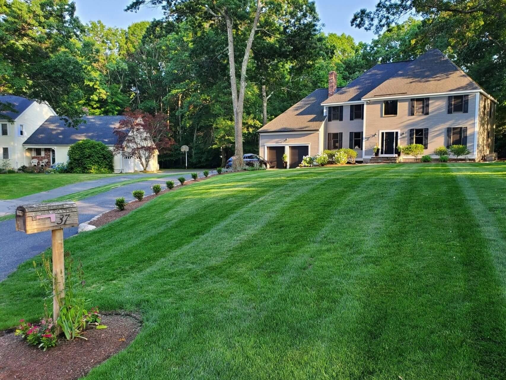 Well-maintained suburban home with lush green lawn and mailbox.