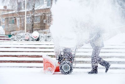 Person using a snowblower to clear snow.