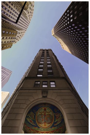 Tall buildings viewed from below against a clear sky.