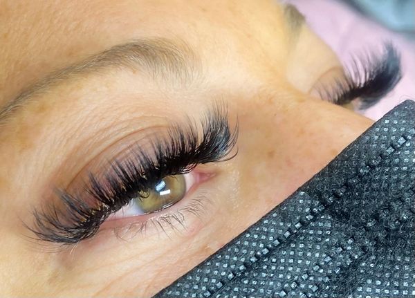 Long volume lash extensions on woman with hazel eyes