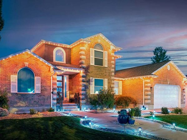 Beautiful lit brick house at dusk.