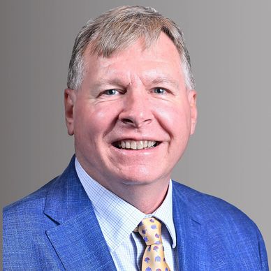 Professional middle-aged man in a blue suit smiling.
