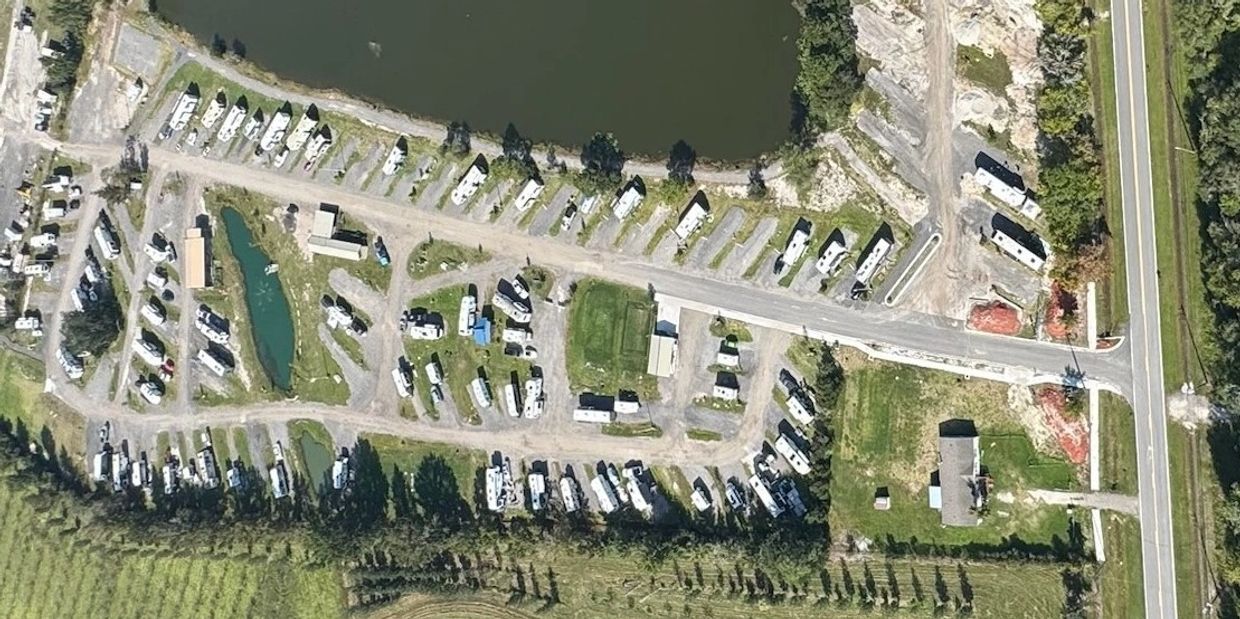 Aerial view of an RV park with many parked trailers and small ponds.