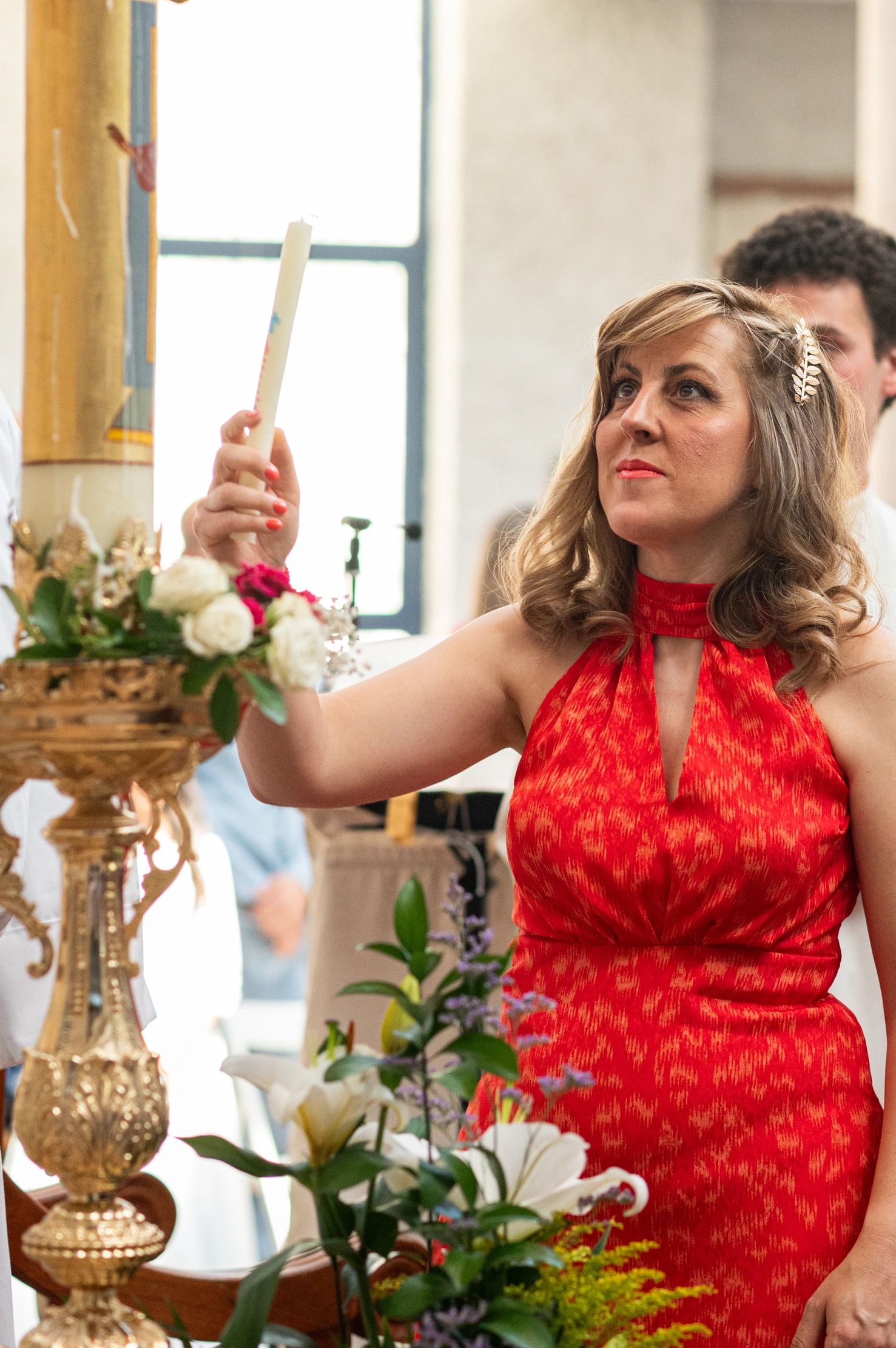Mujer sosteniendo una vela en ceremonia religiosa.