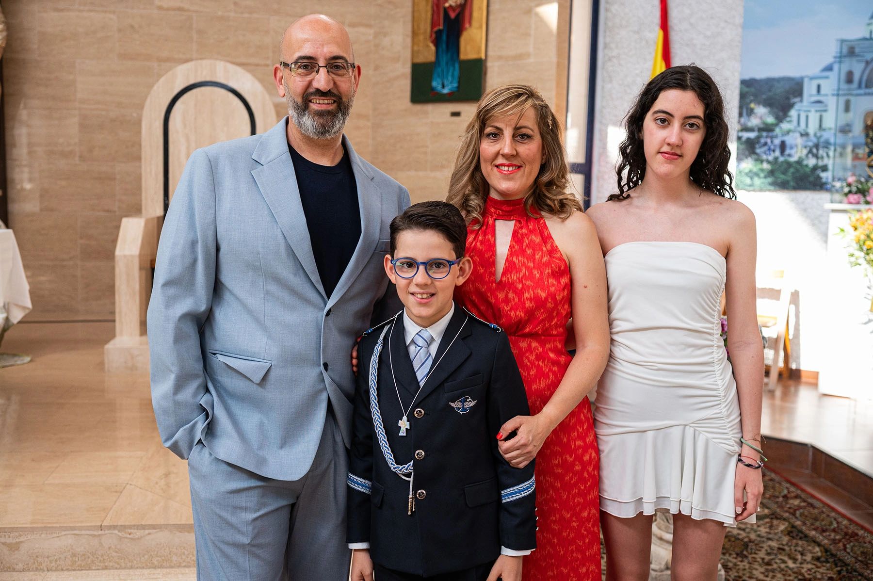 A family of four posing indoors, celebrating a special occasion.
