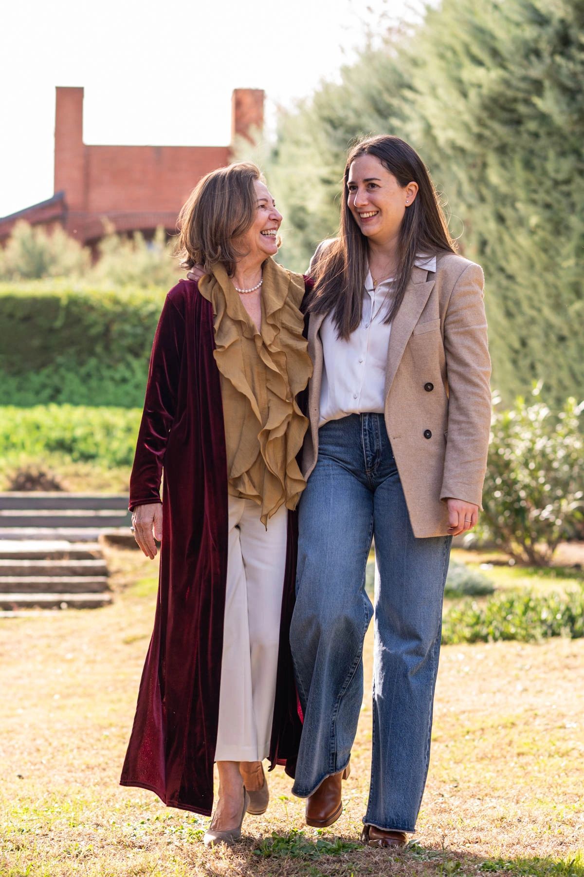 Two women walking outdoors, smiling and enjoying each other's company.