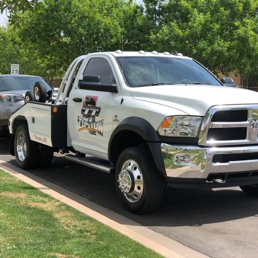 White tow truck parked on the street.