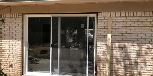Sliding glass door installed on a brick house exterior.