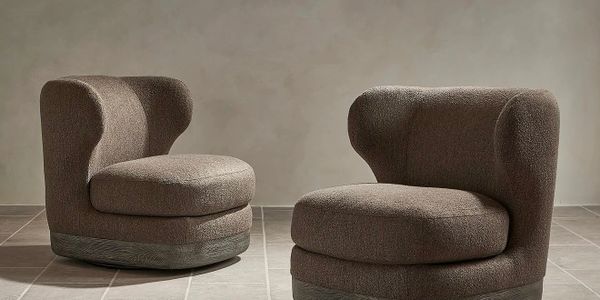 Two modern brown upholstered chairs with rounded backs on tiled floor.
