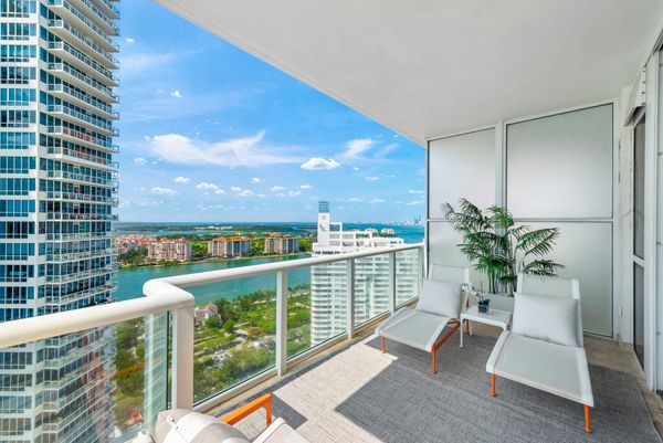 Stylish balcony view overlooking the water with modern lounge chairs