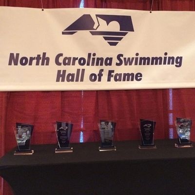 Trophies displayed under a North Carolina Swimming Hall of Fame banner.