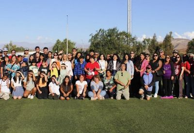 Large group of people posing outdoors on a sunny day.