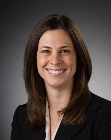 Professional woman smiling in business attire.