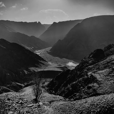 Black and white photo of a mountain range surrounding a crooked valley