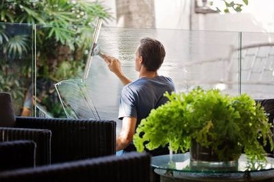 Window cleaner squeegeeing an internal partion