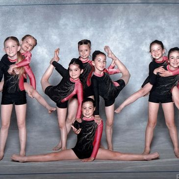 Groupe de jeunes gymnastes posant ensemble en tenue.