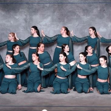 Groupe de danseuses en tenue verte posant en synchronisation.