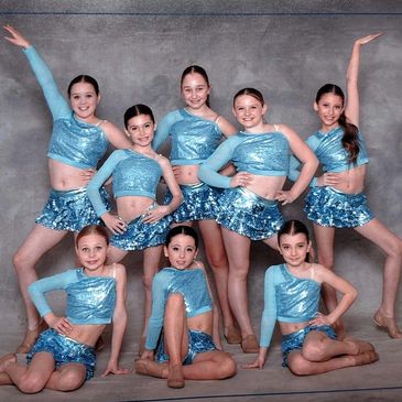 Groupe de jeunes danseuses en costumes bleus.
