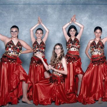 Cinq jeunes filles en costumes rouges de danse traditionnelle.