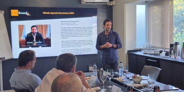 Man giving a presentation to a small group in a modern meeting room.