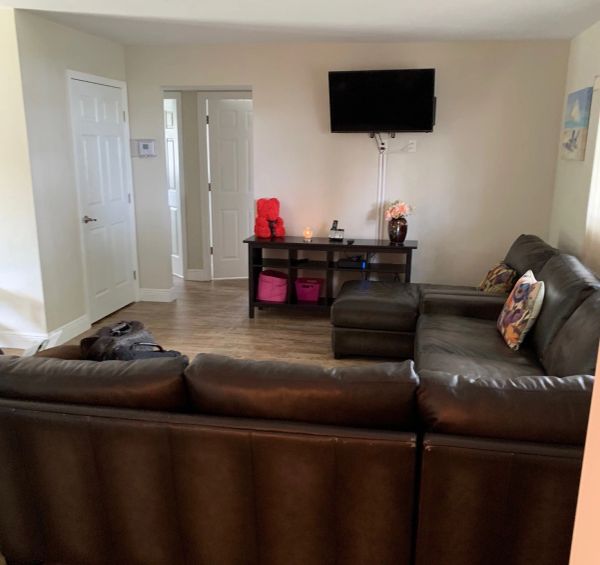 Living room with brown leather couches and a wall-mounted TV.