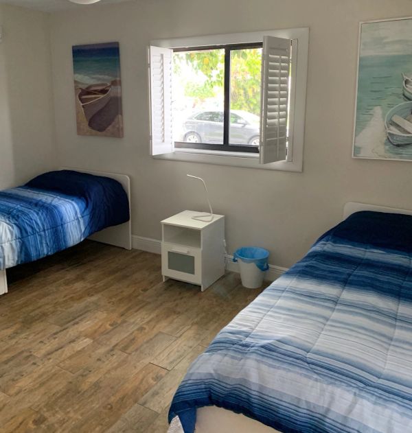 Minimalist room with two twin beds and blue bedspreads.