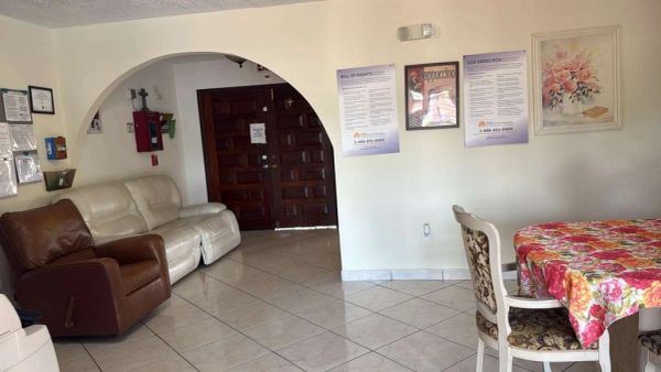 A cozy waiting room with sofas and a floral tablecloth.