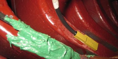 Close-up of red pipes with green insulation and a yellow connector.