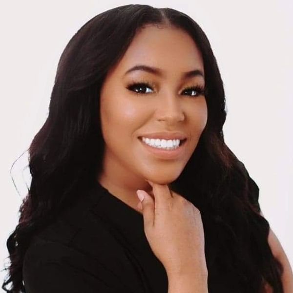 A smiling woman with long hair poses against a white background.